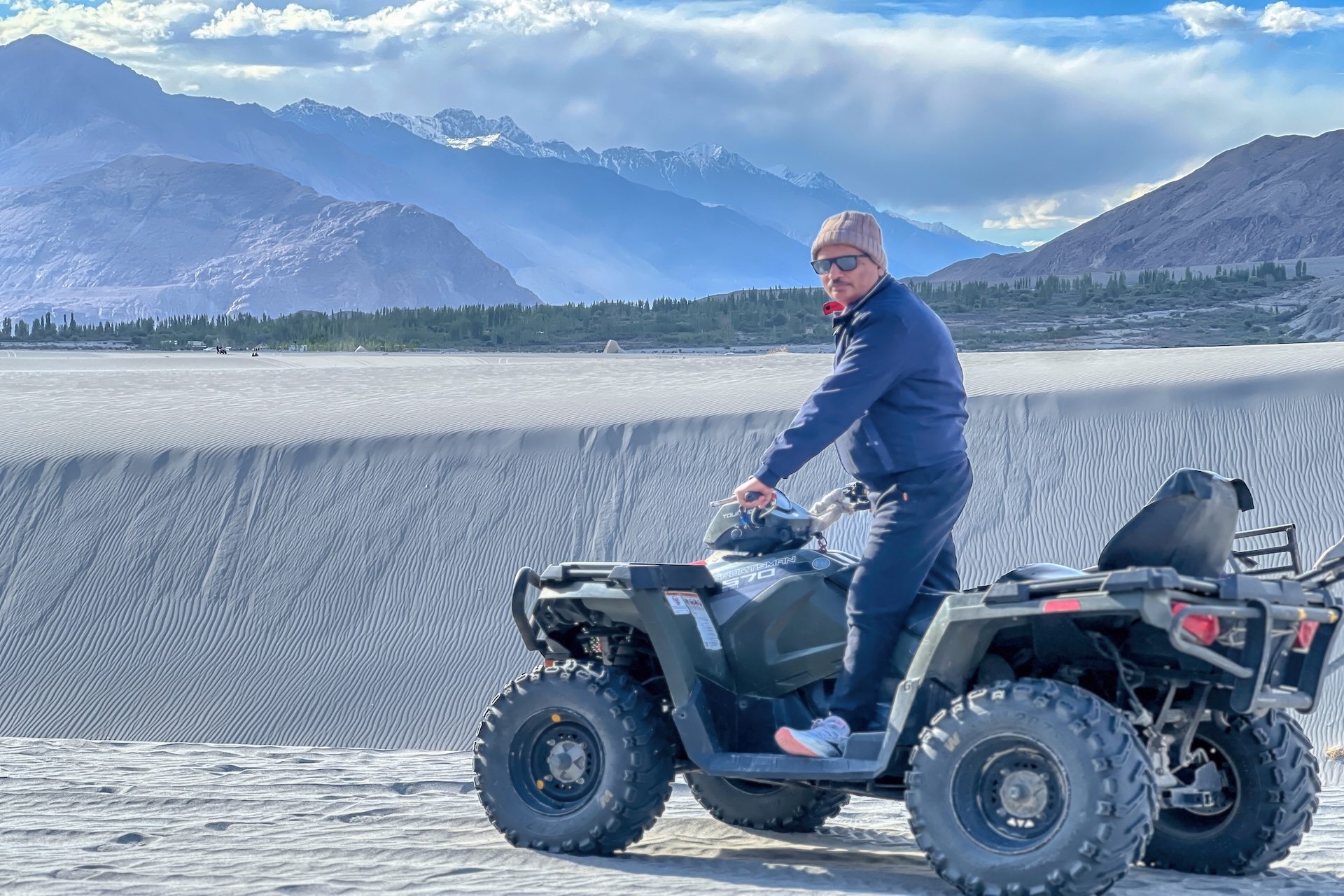 Milkha Point ATV ride on sand dunes in Nubra Valley with mountains in the background