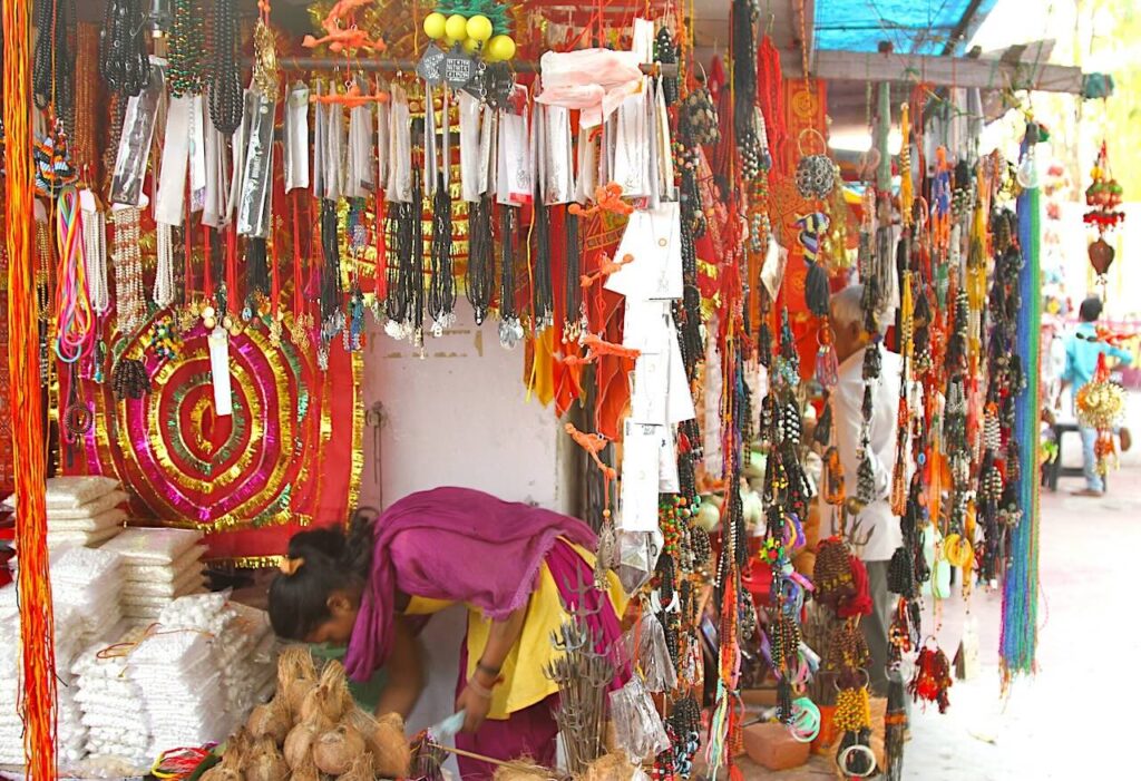Street-side shops selling pools and chadhava items near Gorakhnath Temple in Gorakhpur, India.