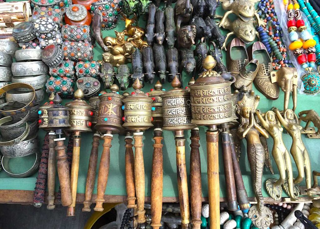 Collection of traditional Tibetan prayer wheels for sale at a souvenir stall on the way to Swayambhunath Stupa