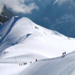 Chamonix Travel Guide: Mountaineers climbing snow-covered Alpine slopes as seen from Aiguille du Midi in Chamonix, French Alps