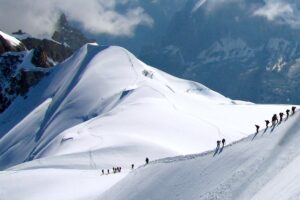 Chamonix Travel Guide: Mountaineers climbing snow-covered Alpine slopes as seen from Aiguille du Midi in Chamonix, French Alps